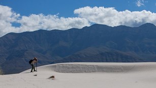 A visitor takes photographs in the gypsum dunes