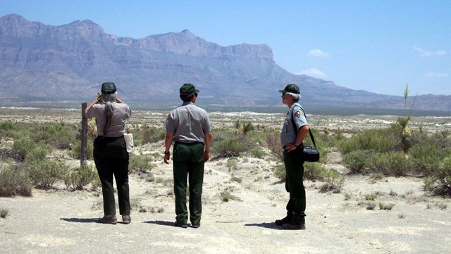 Park staff stand near the salt basin dunes