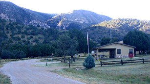 A small ranger station is located along a road in a wide canyon