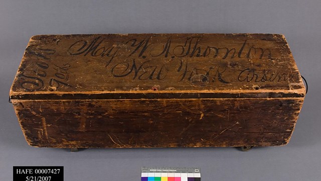 Worn wooden rectangular box with writing on top