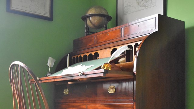 A mahogany desk of the federal style with a chair. 