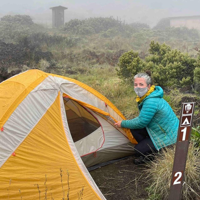 one camper sets up their tent during fog 