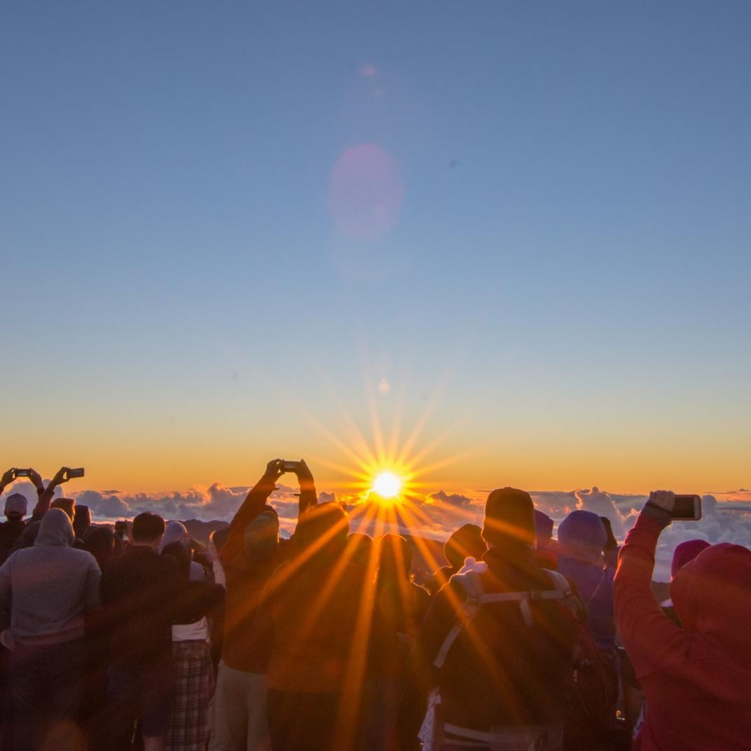 Visitors gather outside the visitor center to watch sunrise.