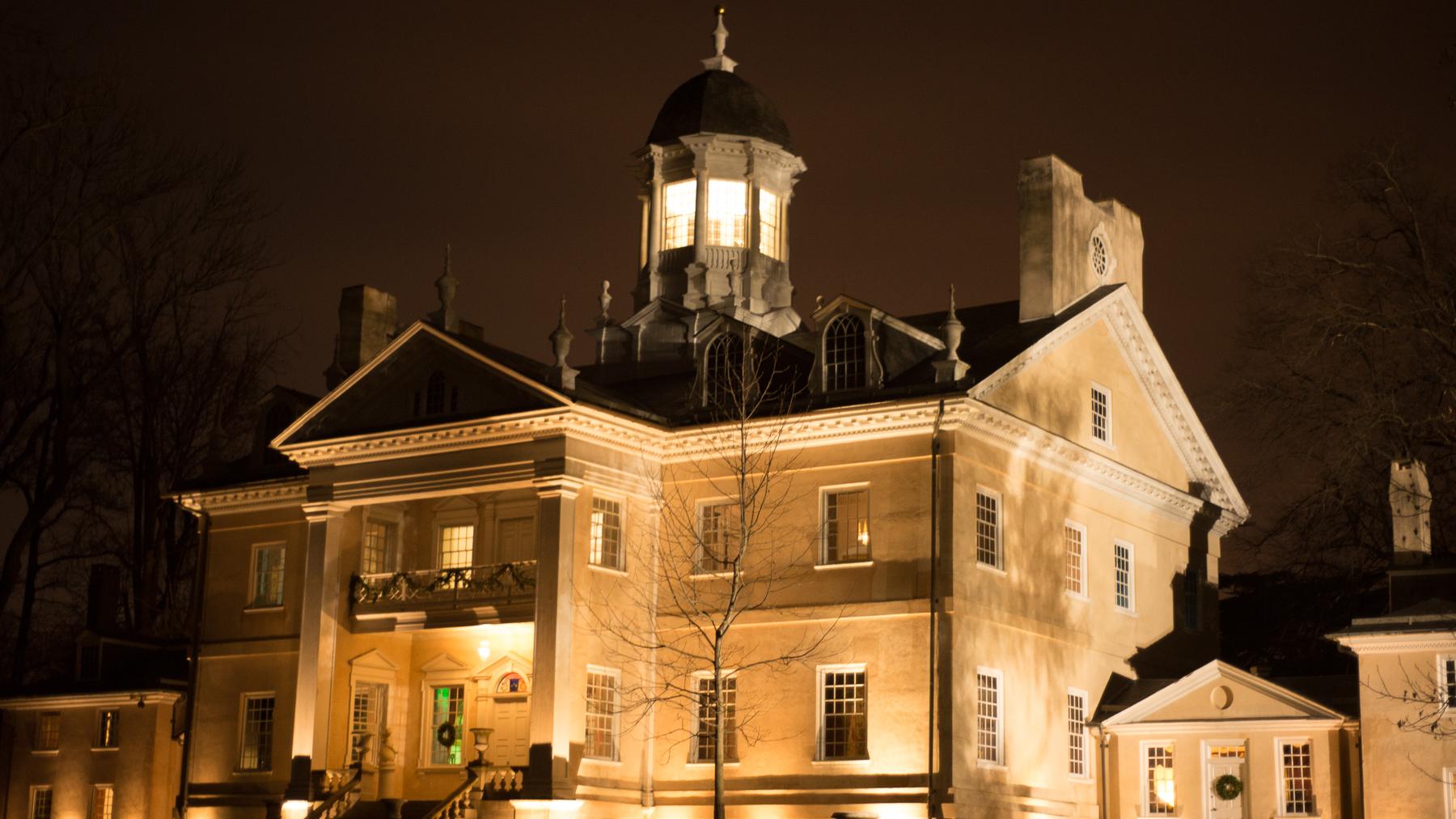 The Hampton mansion lit up at night.