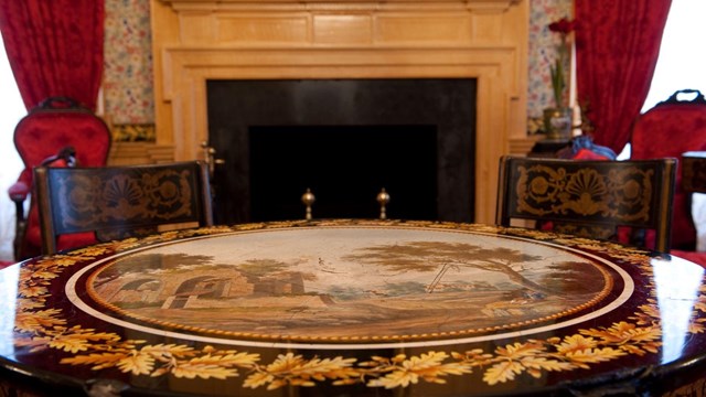 Table and chairs in the drawing room, inside the mansion. NPS/Tim Ervin