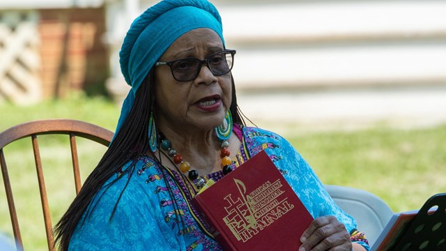 A woman holding a Hymn book