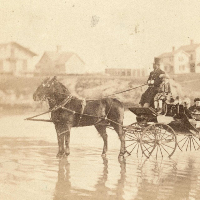 Horse Carriage with people riding in the carriage and horses pulling through rain