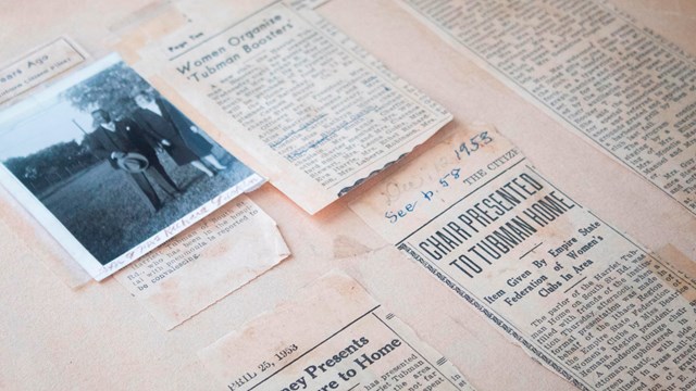 A scrapbook page with newspaper clippings and a small photograph