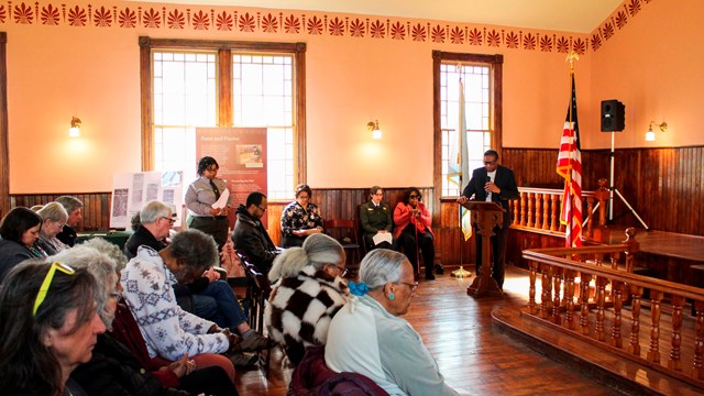 A room full of people watching a man speak.