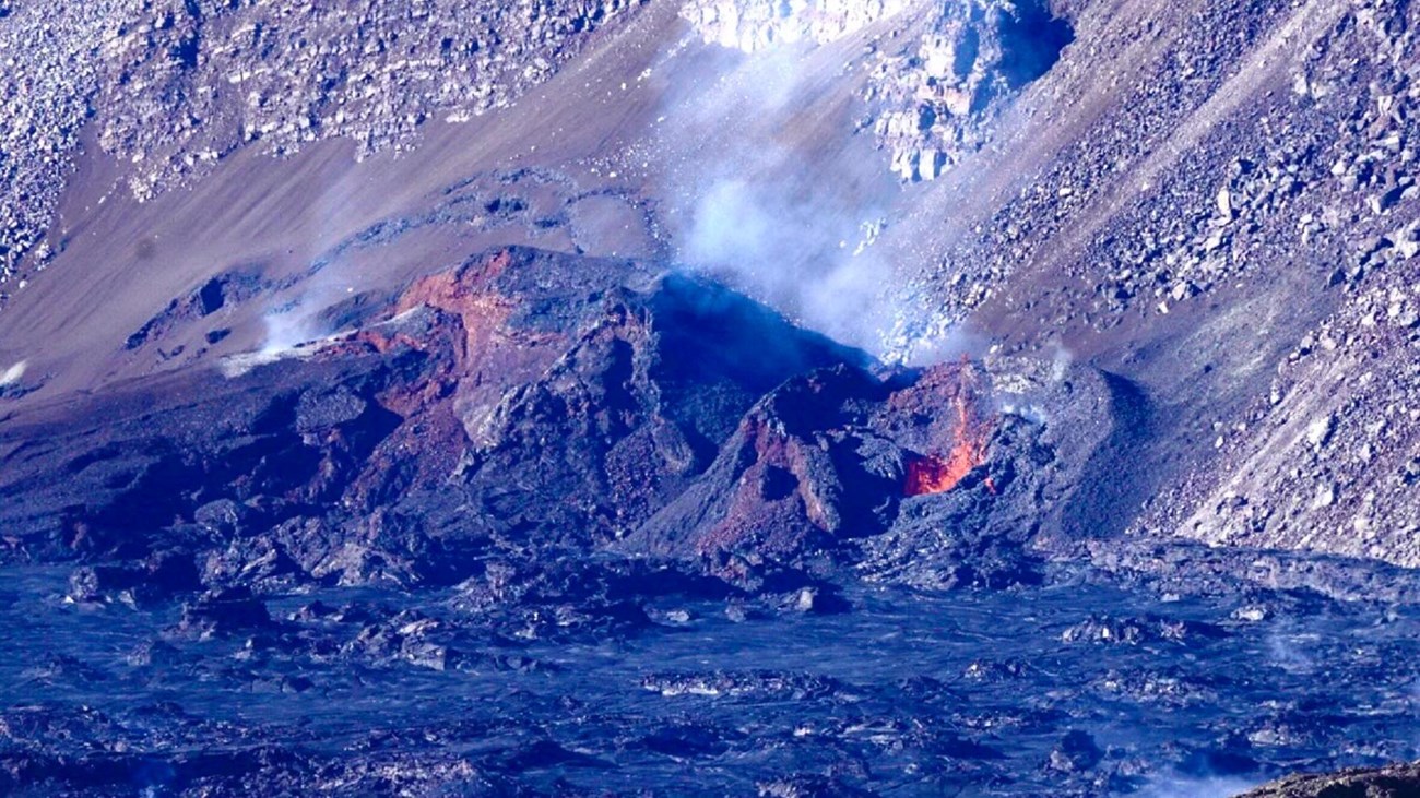 Image of bright orange lava within a crater.