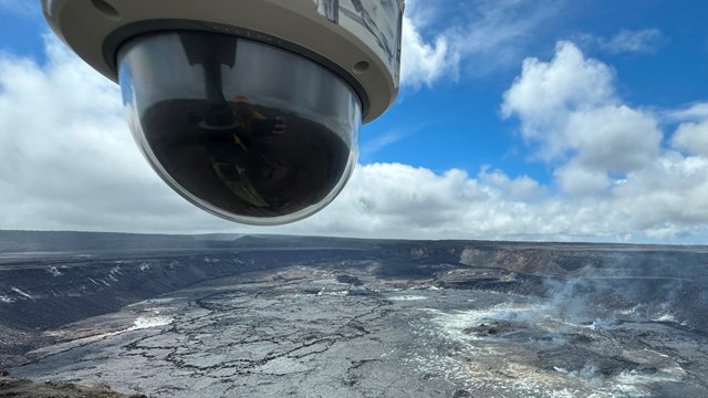 Overlooking massive dark grey volcanic caldera with camera in the top left foreground.