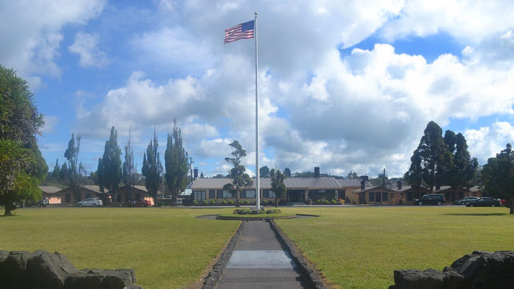 Welcome Center at Kilauea Military Camp behind a large American flag. 