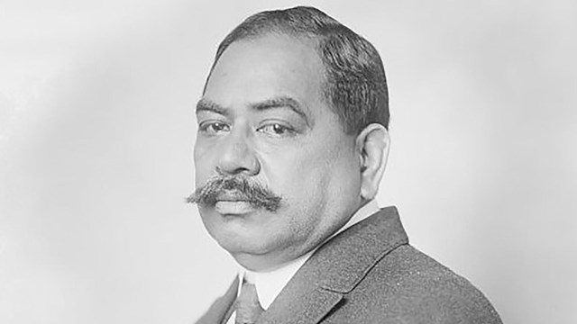 Black and white photograph of a sitting man with a mustache
