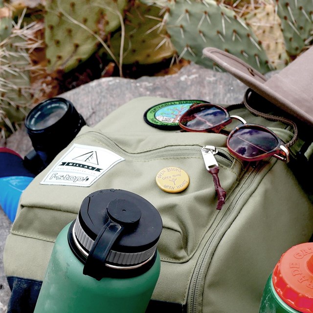 Water bottles, backpack, hat, and sunglasses