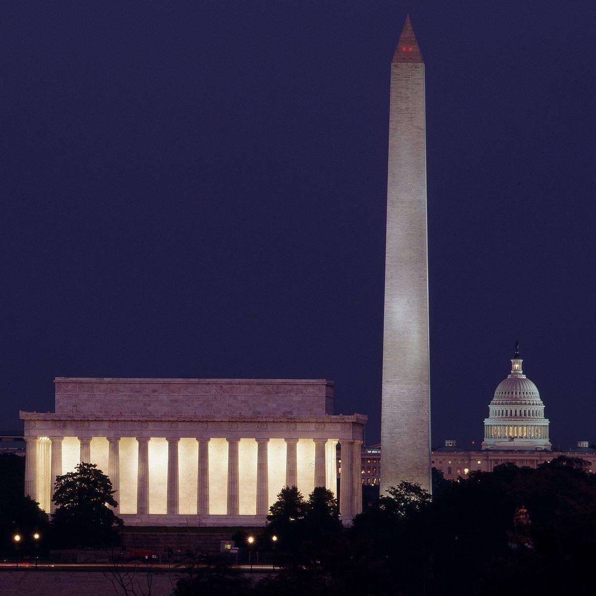 Photo of monuments lite up at night. 