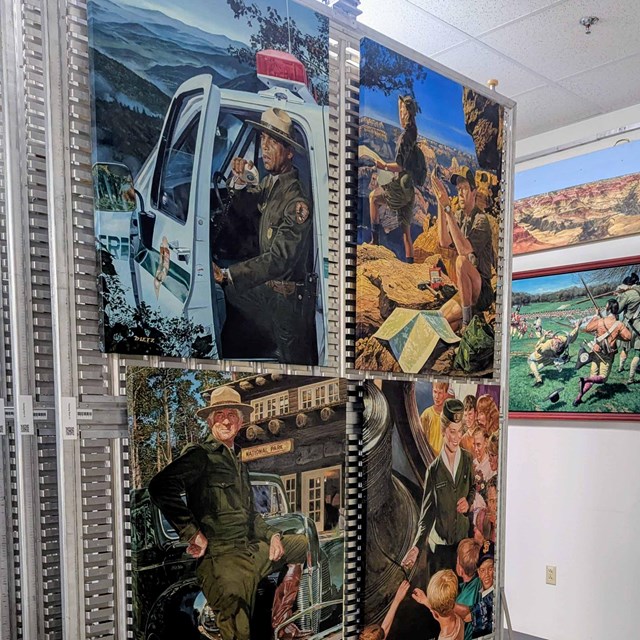 4 colorful, square paintings of rangers outdoors hang one of several sliding, metal walls.