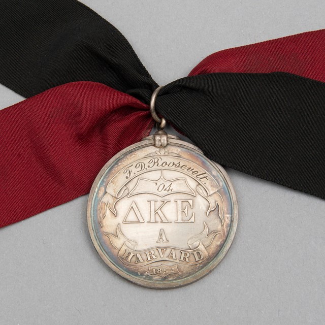 A silver medal with silk ribbons.