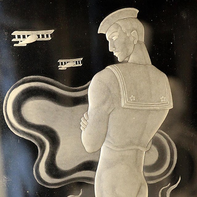 The figure of a sailor from the back side etched in glass.