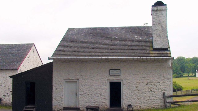 White building with red shed attached. 