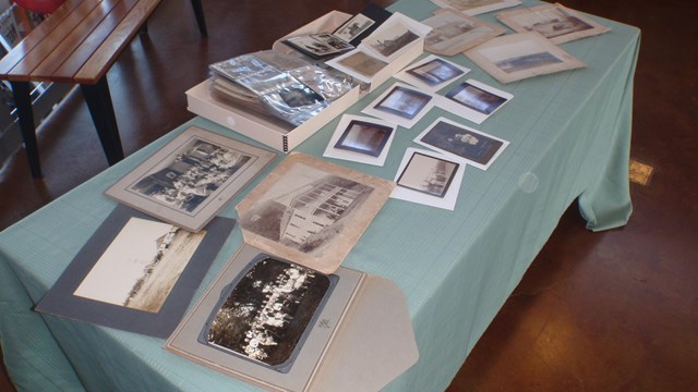 Image is of the Jim Headly photo donation in which a few of the historic photos are laid on a table.