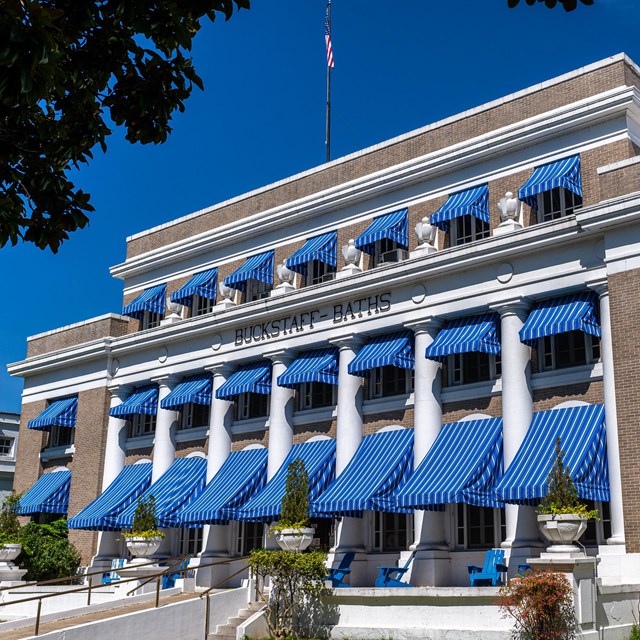 The Buckstaff Bathhouse standing tall featuring its iconic bright blue awnings.