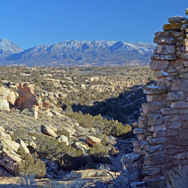 stone structure with canyon and Sleeping Ute Mountain in background