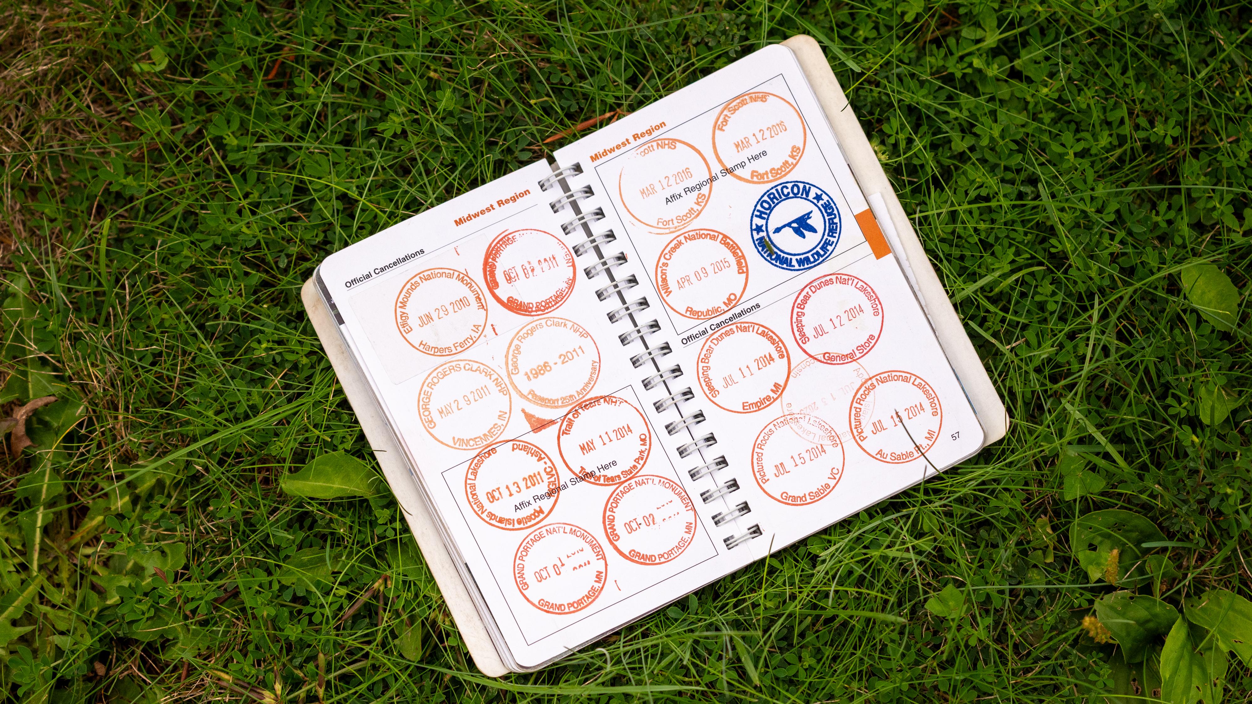 Photograph of spiral bound booklet with numerous circular stamps. 