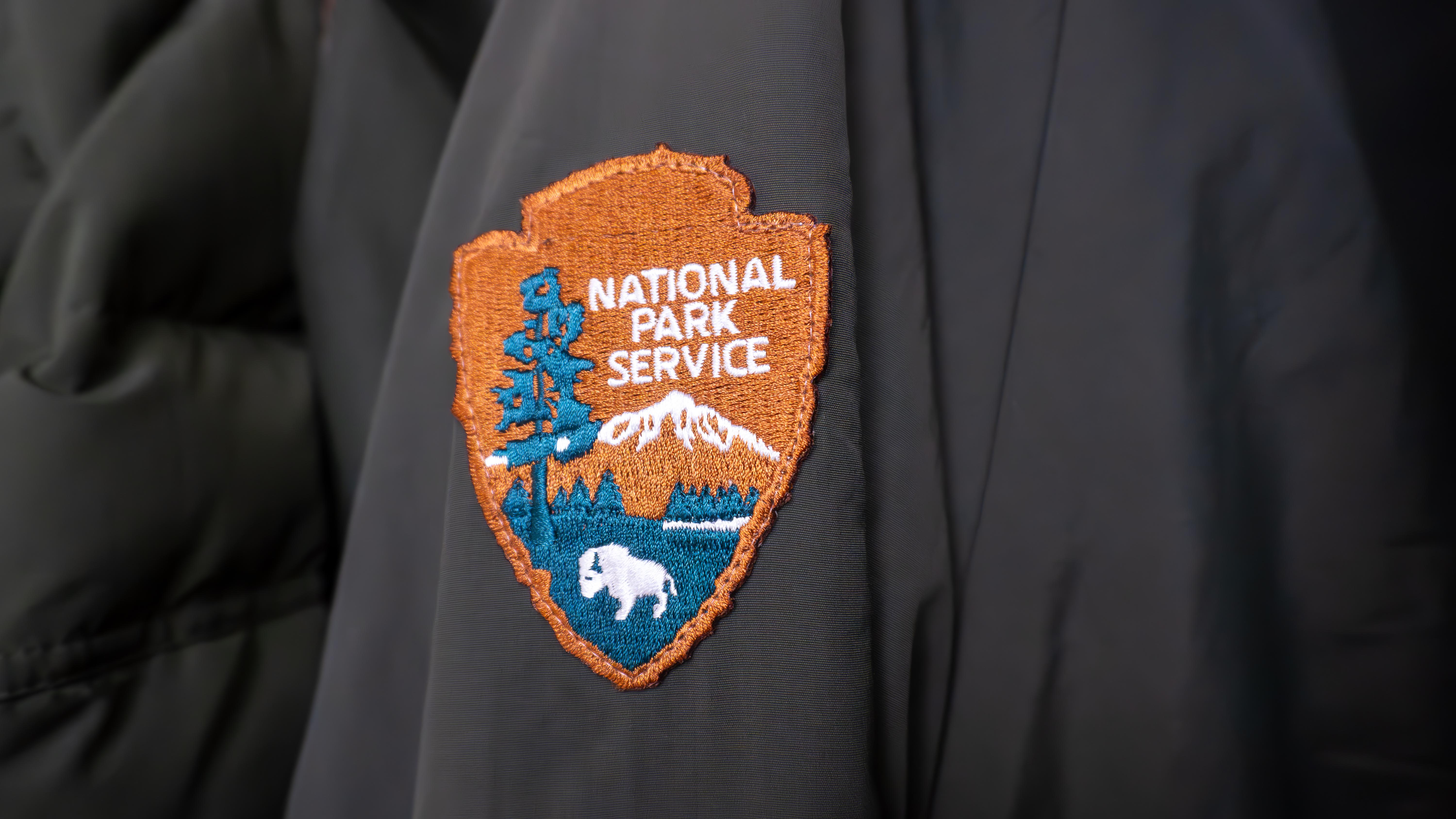 Photograph of NPS arrowhead patch on arm of black jacket.