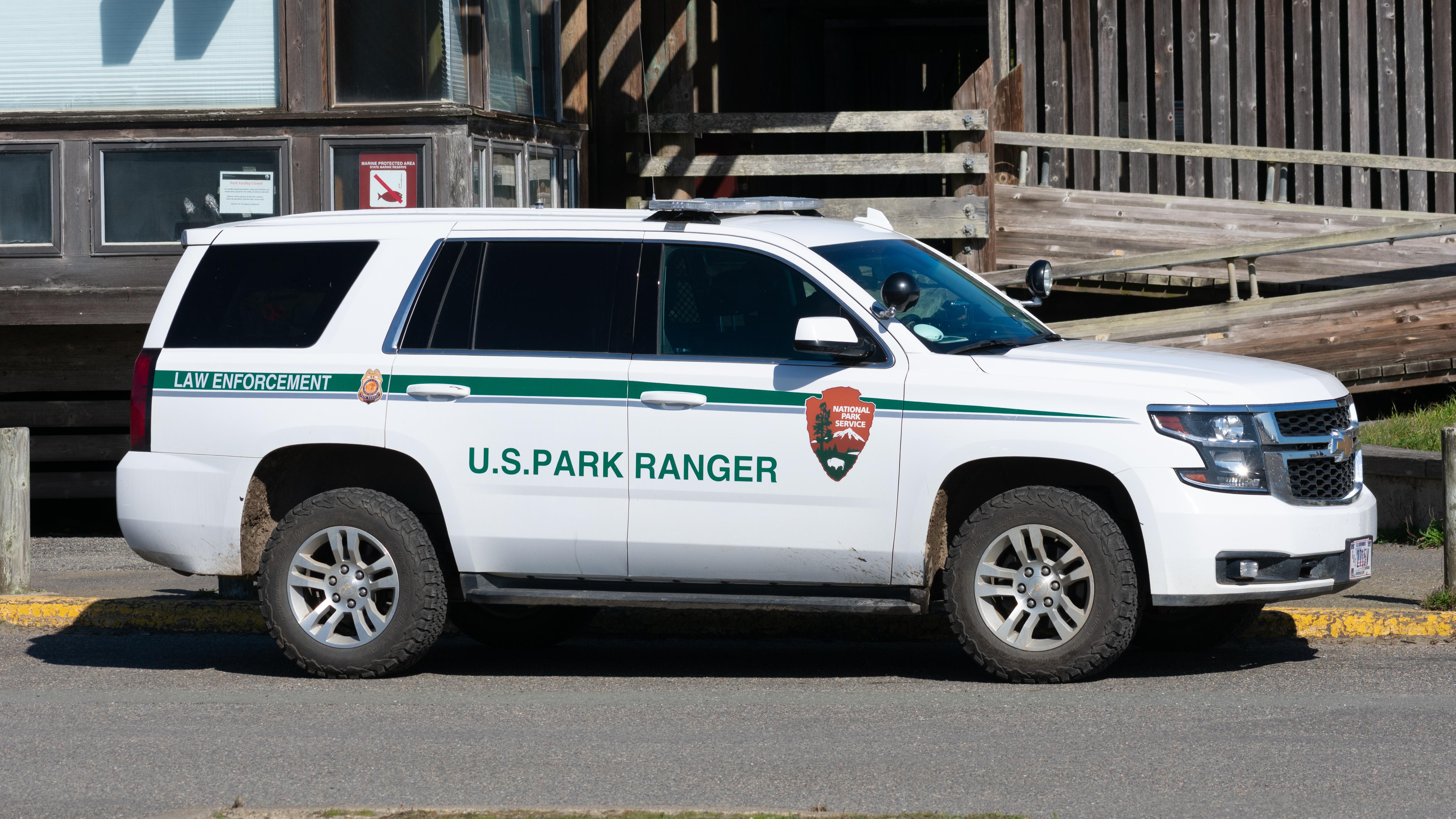 Photograph of white park ranger SUV with NPS livery. 