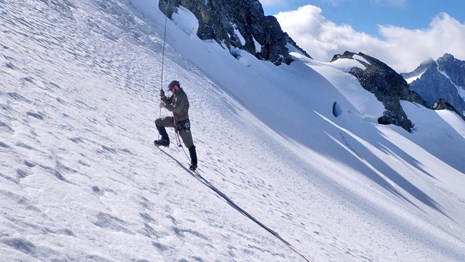 Scientist inserting a probe into a glacier in North Cascades National Park.