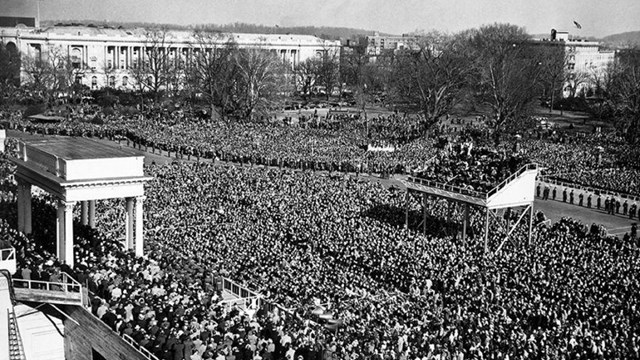 Black and white photo of a large inauguration crowd gathered on a city street