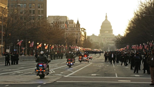Police on motorcycles riding a  parade route towards the US Capitol building