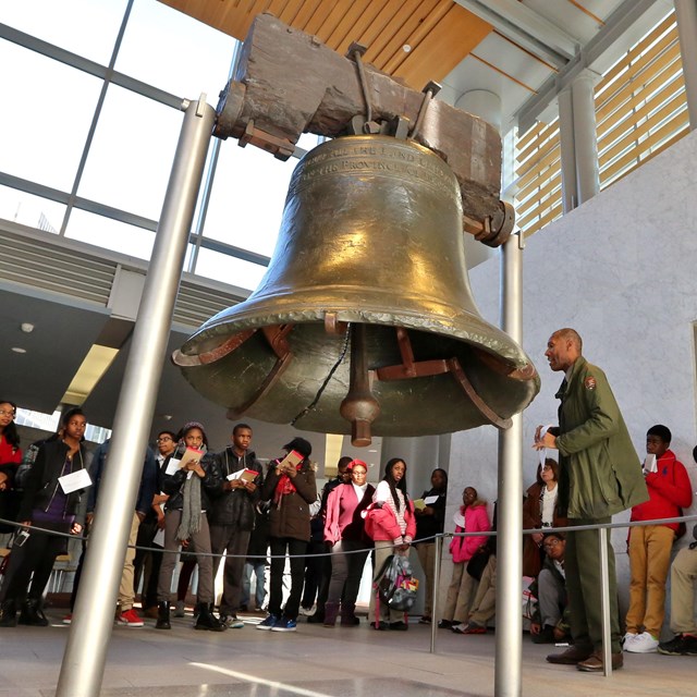 Color photo showing a school group standing around the Liberty Bell.