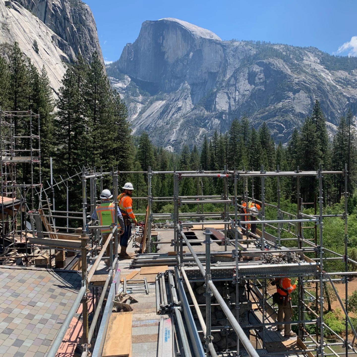 Construction crews and a large crane on a bridge under construction 