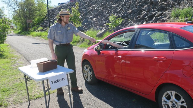 A ranger in uniform hands tickets for the Ranger III in Houghton Michigan.