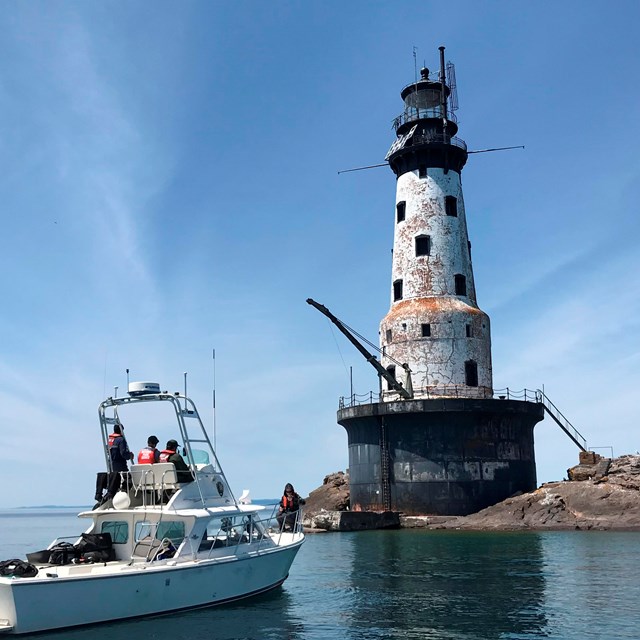 NPS vessel sits in the water in front of Rock of Ages Lighthouse.