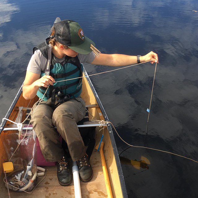 NPS staff test the water quality from a canoe on Lake Superior. 