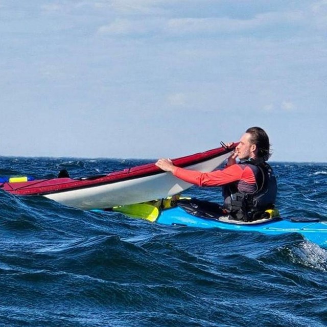 Two kayakers preforming an emergency assist in open lake superior waters.