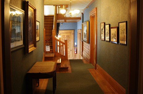 Photo of 2nd floor hall, including original woodwork and reproduction wallpapers from 1880.