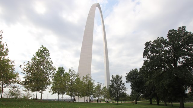 The gleaming stainless steel upside-down U of the gateway arch, with green grass in the foreground