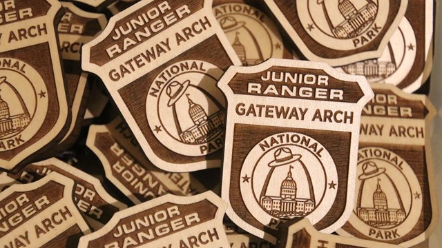 A pile of wooden junior ranger badges.