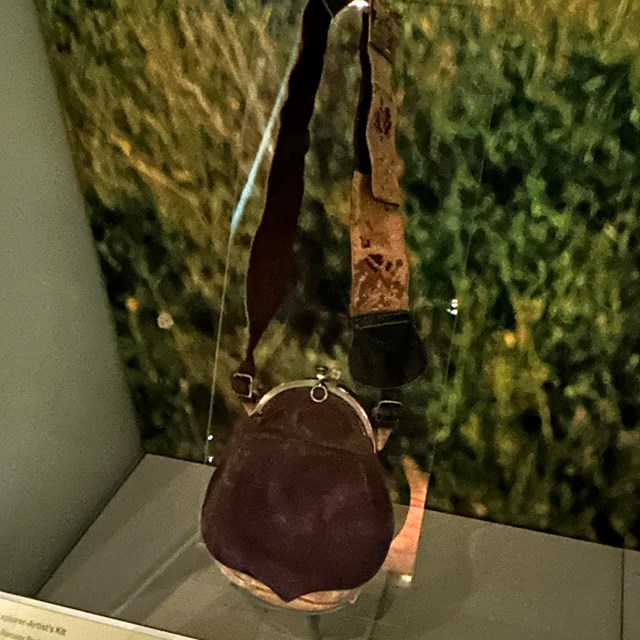 A brown bag with an embroidered strap