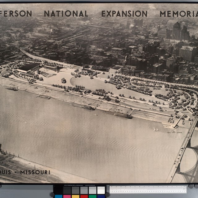 A black and white photo of some buildings next to a river.