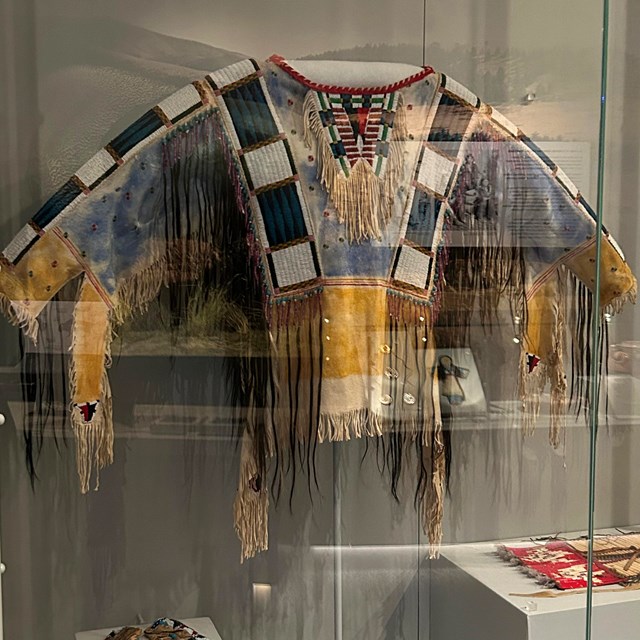 A yellow and blue shirt with beading and hair decorations