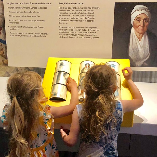 girls using interactive clothing spinner in Colonial gallery