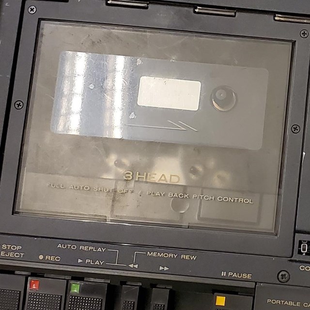 Black, portable cassette tape recorder and player.
