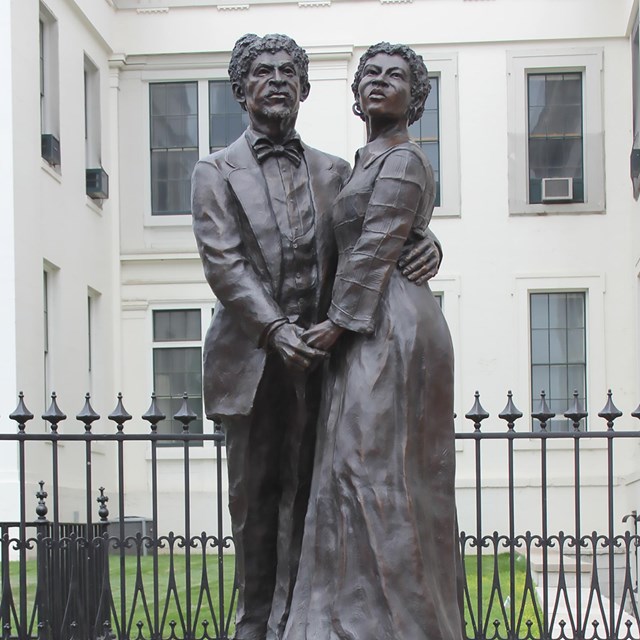 A statue of a man and woman, looking east with hopeful expressions