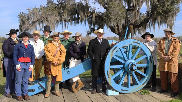 Living historians stand in front of a cannon