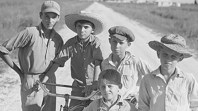 a group of children pose for a picture on a farm.