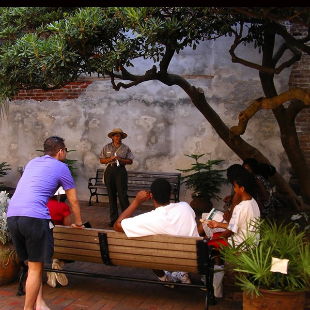 park ranger giving talk to visitors in the courtyard